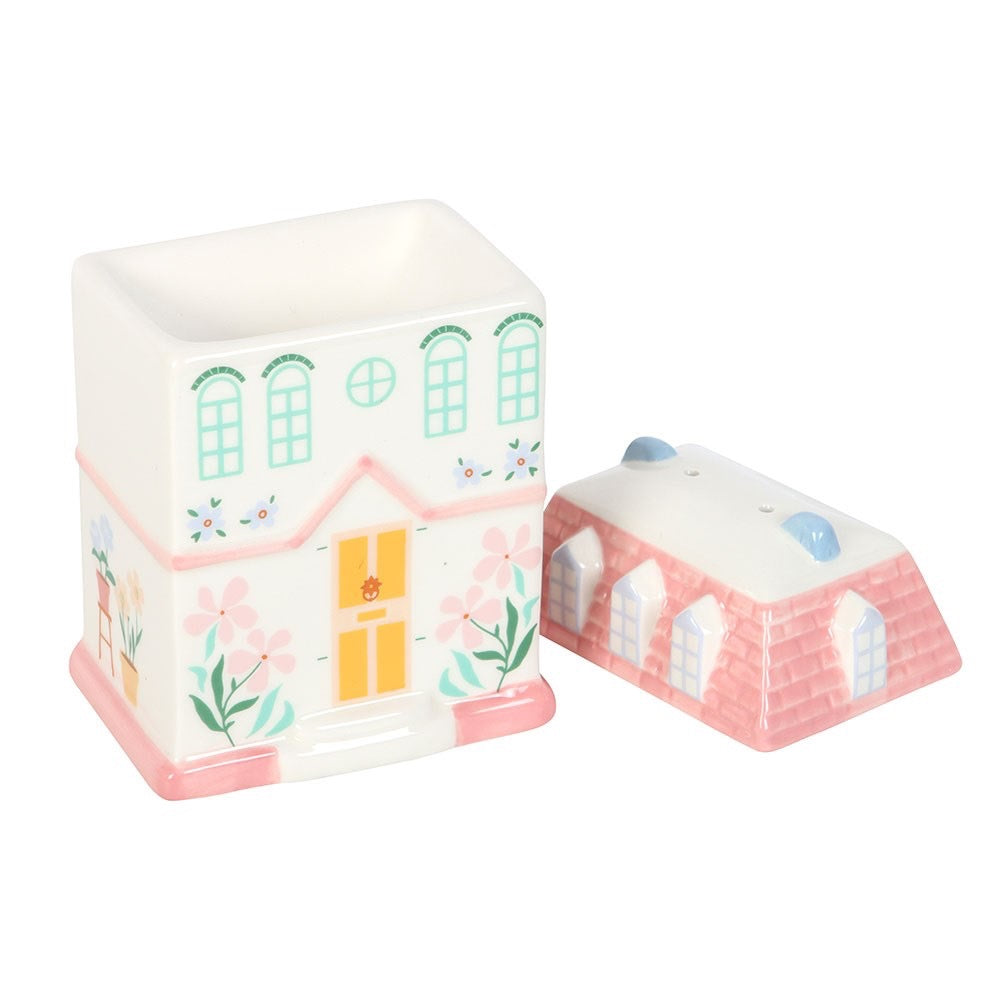 Two ceramic house-shaped containers on a white background