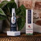 Room spray bottle and packaging with 'sweet wild' branding on a textured surface with plants and a brick wall.